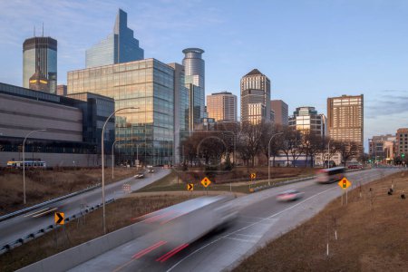 Photo for Traffic blurs into downtown minneapolis during a december sunset - Royalty Free Image