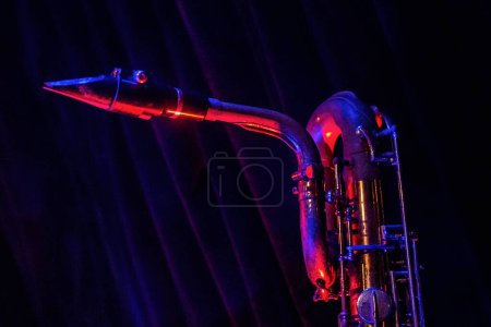 Photo for A close up shot of the neck of willie's baritone saxophone against the stage curtains at 331 club - Royalty Free Image