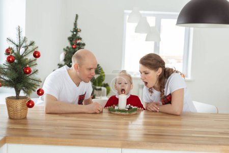 Photo for Baby child with hearing aid and cochlear implant having fun with parents in christmas room. Deaf and health - Royalty Free Image