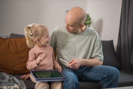 Photo for Deaf child girl with cochlear implant studying to hear sounds - recovery after cochlear Implant surgery and rehabilitation - Royalty Free Image