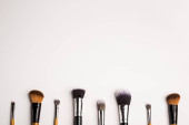 Assorted make up brushes, top view. White background with copy space Poster #645345616