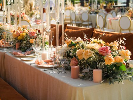 Téléchargez les photos : Mariage. Un banquet. Les chaises et la table ronde pour les invités, servis avec couverts, fleurs et vaisselle et recouverts d'une nappe - en image libre de droit