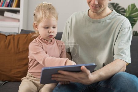 Photo for People with cochlear implant system. Kid study to hear with father, learning with video on tablet. Installation cochlear implant on child girl ear for restores hearing. - Royalty Free Image