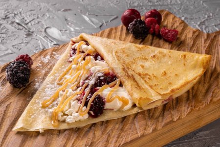 Photo for Pancake or crepe with cottage cheese and berries sweet sauce - Royalty Free Image