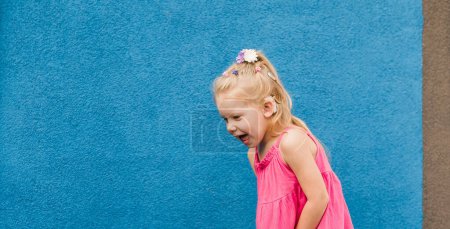 Photo for Child girl walks and have fun outdoor with cochlear implant on the head. Hearing aid and treatment concept. Copy space vertical. - Royalty Free Image