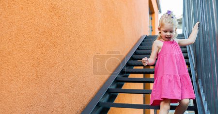 Photo for Funny baby with cochlear implant walks outdoor. Hearing aid and medicine innovating technology concept. Diversity and inclusion. Copy space. - Royalty Free Image