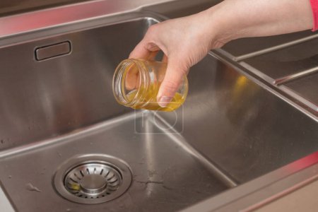 Téléchargez les photos : Vieille huile de cuisson versée dans les déchets de cuisine, obstruant l'évier avec de l'huile - en image libre de droit