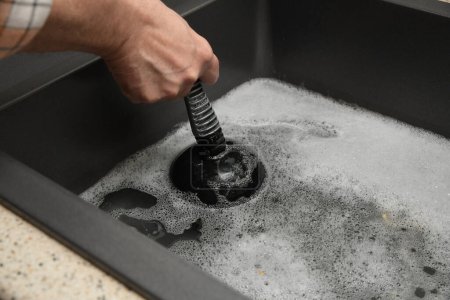 Overflowing kitchen sink, clogged drain, plumbing problems, trying to unclog