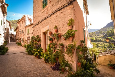 Malerische Gasse mit Blumen in einer spanischen Hügelstadt, kleines Dorf Soller