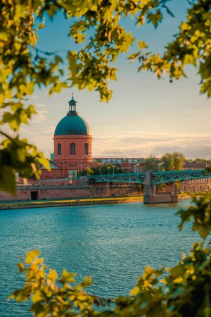 Foto de Toulouse, Francia. Hermoso paisaje urbano con el río Garona y la cúpula de La Grave en el fondo al atardecer - Imagen libre de derechos