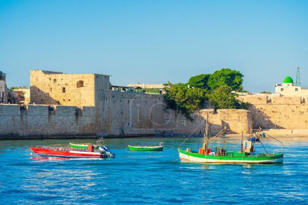 Photo for Akko or Acre city walls, a historic town in Israel. Citiscape featuring anchored boats - Royalty Free Image