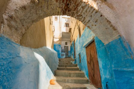 View of a picturesque street painted in blue featuring steps and arches  in an old medina of Tetouan, Morocco, North Africa