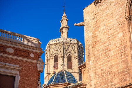 Der Glockenturm der Kathedrale von Valencia erhebt sich an einem sonnigen Tag hinter dem alten Gebäude des Stadtteils Ciutat Vella