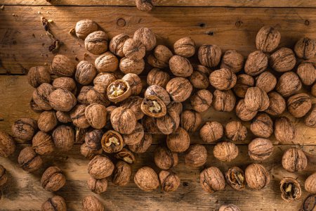 Photo for Scattered walnuts nut on wooden table close up top view - Royalty Free Image