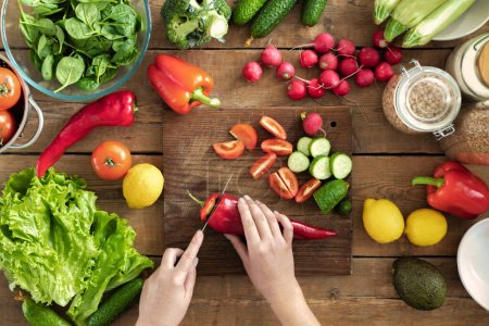 Photo for Set of various fresh vegetables for cooking healthy summer food on wooden table top view. Female hands preparing fresh salad - Royalty Free Image