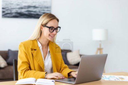 Photo for Young business woman typing on laptop keyboard, happy work. Smiling woman entrepreneur sitting at her workplace in the modern office and working - Royalty Free Image