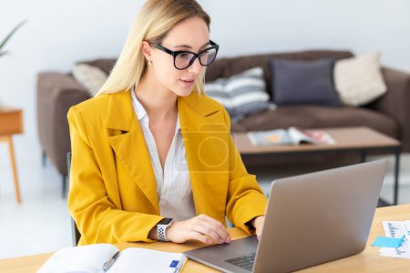 Photo for Young woman working with laptop. Concentrated businesswoman at work sitting in the office - Royalty Free Image