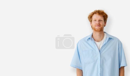 Photo for Portrait of caucasian redhead young man in blue shirt standing on a white background with copy space, looking at camera - Royalty Free Image