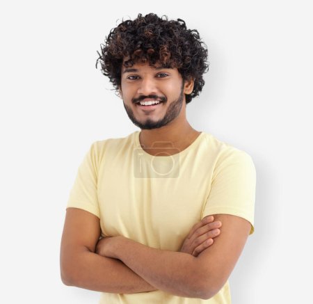 Photo for Happy Asian man with curly hair and white teeth in yellow t-shirt standing on white background looking at camera and smiles friendly - Royalty Free Image