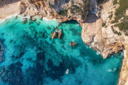 Photo for Beautiful summer seascape from air. Turquoise sea water, rocks, boat and small sandy beach from top view, Island of sardinia in Italy. Travel background, aerial view drone shot - Royalty Free Image