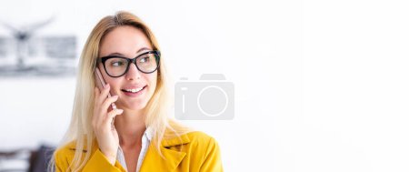 Photo for Portrait of young positive female confident entrepreneur or small business owner with glasses in a modern office. Smiling successful businesswoman talking on mobile phone, looking away and smiles - Royalty Free Image