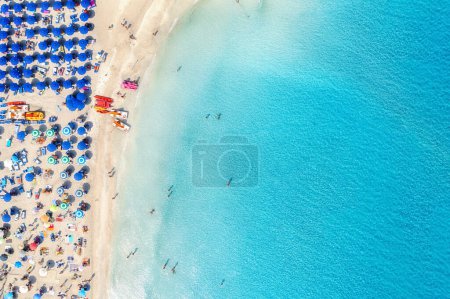 Photo for Top view of beautiful sandy popular beach La Pelosa with turquoise sea water and colorful blue umbrellas, Islands of Sardinia in Italy, aerial drone shot - Royalty Free Image