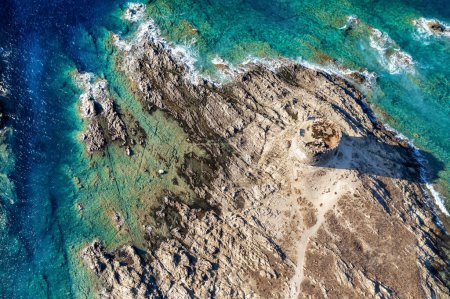 Photo for Beautiful summer seascape from air. Ancient tower with turquoise sea water, waves and rocks from top view, La Pelosa is a popular beach in the island of sardinia in Italy aerial drone shot - Royalty Free Image
