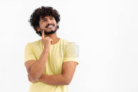Foto de Pensativo asiático masculino sobre fondo blanco contempla algo, pensando en una idea - Imagen libre de derechos