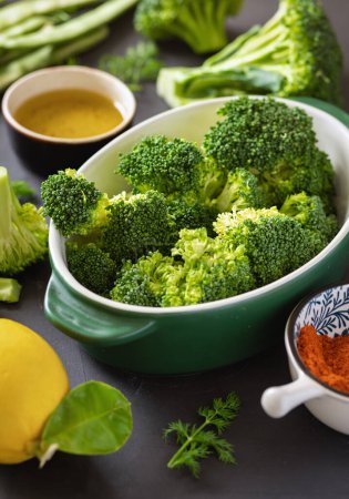 Foto de Ingredientes crudos para cocinar alimentos vegetarianos saludables. Brócoli, judías verdes, limón y especias - Imagen libre de derechos