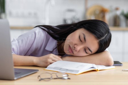 Foto de Primer plano retrato de mujer asiática cansada freelancer o estudiante durmiendo en el lugar de trabajo en casa. Privación crónica del sueño, concepto de exceso de trabajo - Imagen libre de derechos