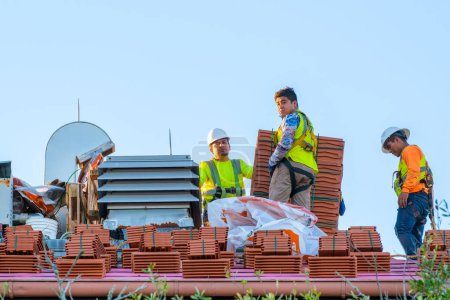 Téléchargez les photos : NEW ORLEANS, LA, USA - JANUARY 4, 2023: Roofers and roofing tiles during prepping for renovation atop Tulane University building - en image libre de droit