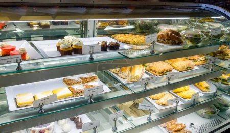 Photo for Assortment of pastries and sandwiches in a display case at a modern bakery shop in New Orleans, Louisiana, USA - Royalty Free Image