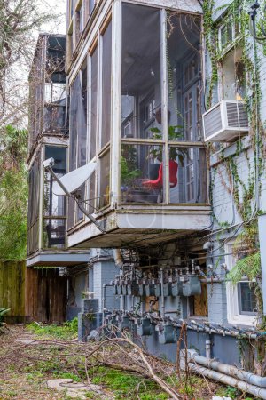 Téléchargez les photos : NEW ORLEANS, LA, USA - FEBRUARY 2, 2023: Rear view of old weathered apartment building showing screened balconies and electrical meters - en image libre de droit