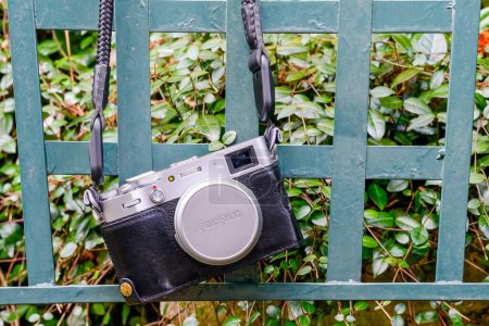 Photo for NEW ORLEANS, LA, USA - FEBRUARY 22, 2023: Closeup of Fujifilm X100V camera hanging from a lawn chair in the garden - Royalty Free Image