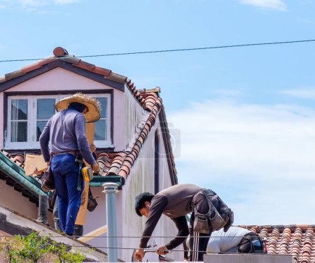 Foto de NEW ORLEANS, LA, Estados Unidos - 24 de abril de 2023: Trabajadores reemplazando un tejado de tejas en el edificio Uptown - Imagen libre de derechos