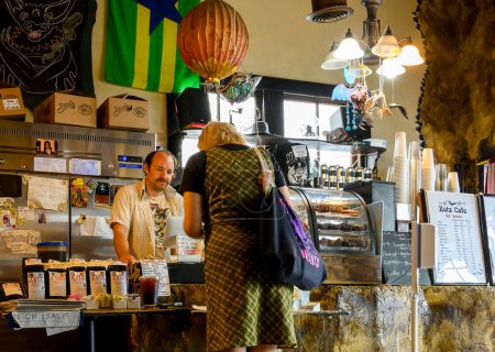 Téléchargez les photos : NEW ORLEANS, LA, USA - 8 AOÛT 2023 : Une cliente passe sa commande chez le barista au comptoir du Zotz Cafe sur Oak Street - en image libre de droit