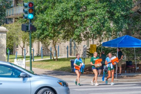 Photo for NEW ORLEANS, LA, USA - AUGUST 15, 2023: Three freshmen women carry athletic shoeboxes as they cross the street at McAllister and Willow Streets on the Tulane University Campus - Royalty Free Image