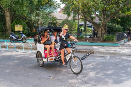 Téléchargez les photos : NEW ORLEANS, LA, États-Unis - 24 septembre 2023 : Guide touristique pour Cajun Queen Tours transporte les touristes dans un taxi tricycle dans le quartier français - en image libre de droit