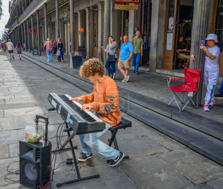 Téléchargez les photos : NOUVELLE-ORLÉANS, LA, ÉTATS-UNIS - 22 OCTOBRE 2023 : Un jeune homme joue du piano pour rassembler des touristes le long de Jackson Square dans le Quatuor français - en image libre de droit