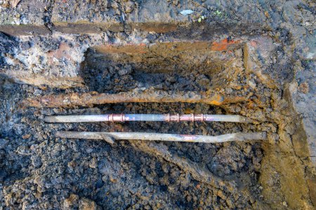 Téléchargez les photos : Trois vieux tuyaux extérieurs exposés affichant des réparations faites à un tuyau d'eau en cuivre - en image libre de droit