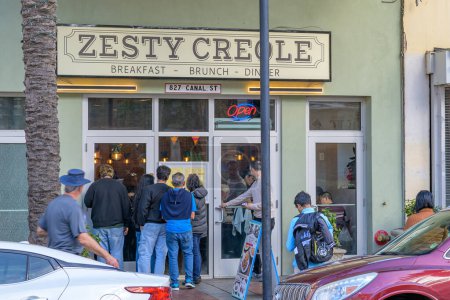 Foto de NEW ORLEANS, LA, Estados Unidos - 31 de diciembre de 2023: Frente al restaurante Zesty Creole en Canal Street con multitud y transeúntes en la acera - Imagen libre de derechos