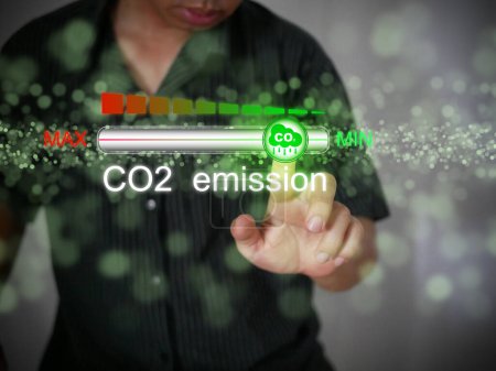 Photo for Carbon dioxide emissions control and reduction or removal to limit global warming and climate change. A man adjusting the volume of CO2 emission on the progress bar to min. - Royalty Free Image