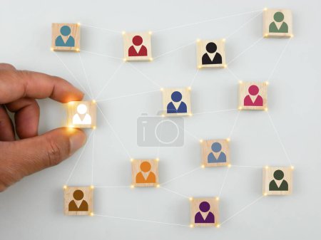 Foto de Wooden blocks with people icons in different colors. Building or developing a strong team, human resources and management concept, HR and HRM - Imagen libre de derechos