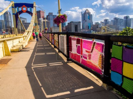Photo for Textile arts on Pittsburgh bridge with people walking across. - Royalty Free Image