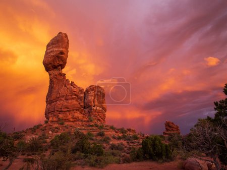 Photo for The Balanced Rock in Arches National Park, Utah, is a stunning natural wonder that has captivated visitors for years. This unique geological formation, which stands tall against the dramatic clouds of a colorful sunset. - Royalty Free Image
