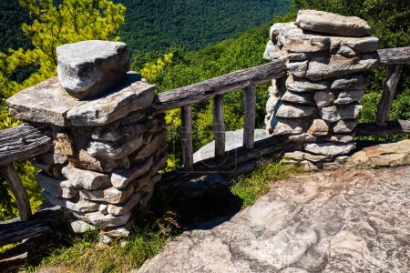 Téléchargez les photos : La photo représente une clôture en bois et deux piliers en pierre au Coopers Rock surplombant la Virginie-Occidentale. La clôture longe le bord de la falaise et les piliers sont stratégiquement placés pour le soutien. La scène offre une vue claire et dégagée de - en image libre de droit