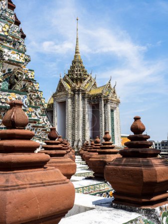 Photo for At the Wat Arun Temple, the Temple of Dawn, one building stands out with its magnificent golden roof and spire. The terracotta pyramids surrounding it create a stunning contrast, adding to the grandeur of the temple, which is an important site for Bu - Royalty Free Image