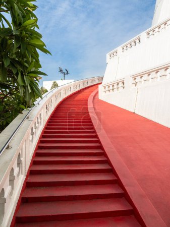 Photo for Gracefully curved and vibrantly red, a staircase ascends to the summit of Bangkok's Wat Saket, the Golden Mount. - Royalty Free Image