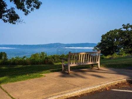 Photo for Bench illuminated by the late afternoon sun, offering a Shenandoah Valley panorama, situated at the Dickey Ridge Visitor Center within Shenandoah National Park, Virginia, USA. - Royalty Free Image