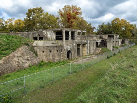 Téléchargez les photos : Les ruines abandonnées de Fort Washington, Virginie, avec des arbres aux couleurs automnales et un ciel spectaculaire au-dessus. - en image libre de droit